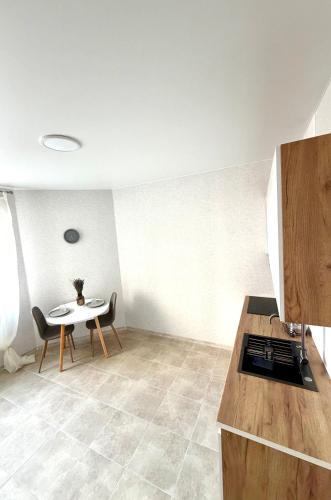 a kitchen with a table and a table and chairs at НОВИЙ ЖК ОДЕСЬКІ ТРАДИЦІЇ НА ГЛУШКО!є підземний паркінг! in Odesa