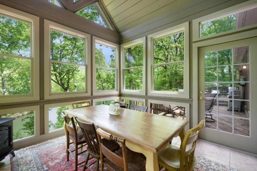 a dining room with a table and windows at - Dawsonville, GA - Take in Beautiful Lake Views, Kick Off a Game of Foosball, Cozy Up by the Fireplace, and Unwind on the Scree in Dawsonville