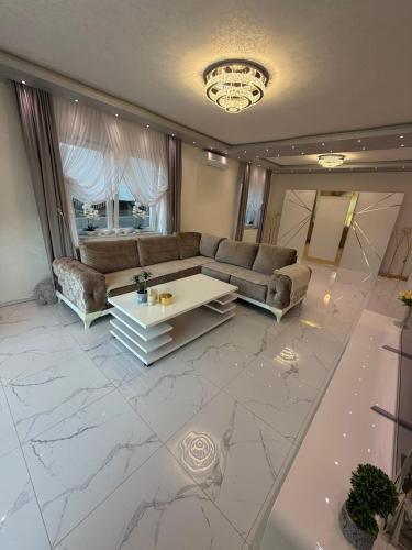 a living room with a couch and a table at Luksuzna kuca sa bazenom 