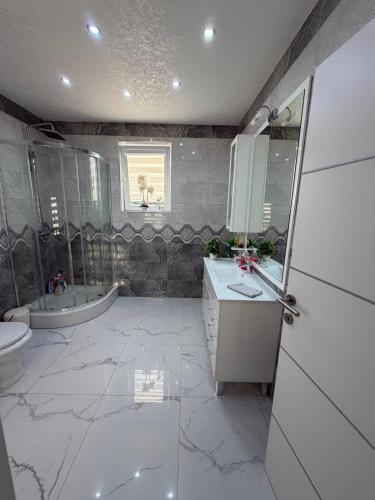 a bathroom with a sink and a toilet and a tub at Luksuzna kuca sa bazenom 