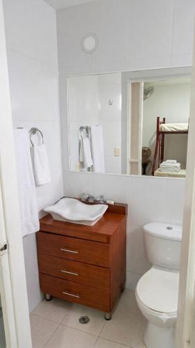 a bathroom with a sink and a toilet and a mirror at Tu refugio ideal cerca al mar in Playa Bello Horizonte