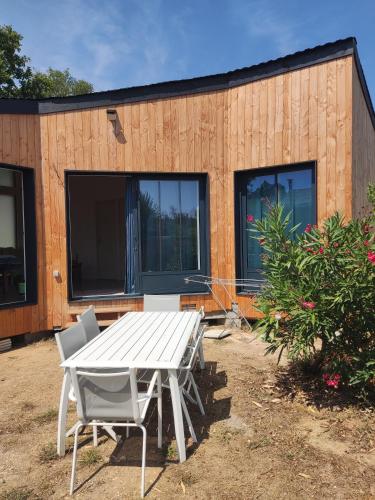 a table and chairs in front of a house at Chalet Ø2 - lumineux et climatisé - proche plage in La Brée-les-Bains