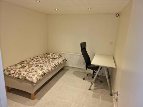 a bedroom with a bed and a desk and a chair at Rimbo Hem in Rimbo