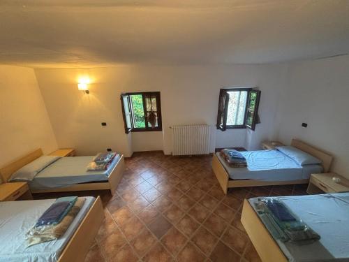 a room with three beds and two windows at Guest House Villa Castello in Nucetto