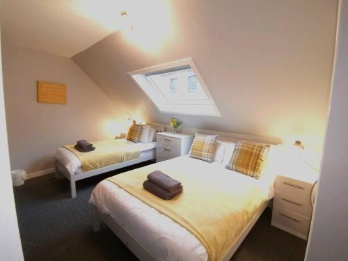 a attic bedroom with two beds and a skylight at Superhost House Brechin sleeps 6, 3 bedrooms in Brechin