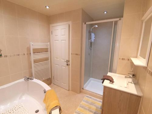 a bathroom with a tub and a sink and a shower at Superhost House Brechin sleeps 6, 3 bedrooms in Brechin