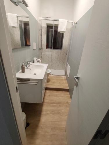 a white bathroom with a sink and a mirror at Casa Engy in Rocca Imperiale