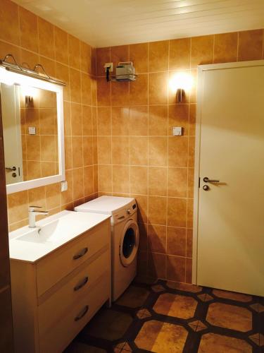 a bathroom with a sink and a washing machine at Merekalda Puhkemaja in Orjaku