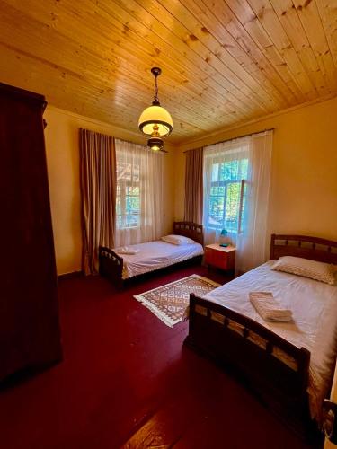 a bedroom with two beds and a wooden ceiling at Beghela in Glola