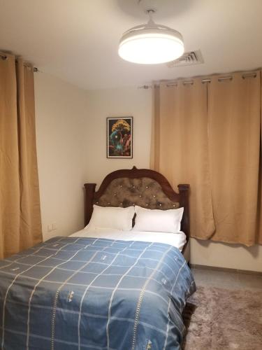 a bedroom with a bed with a blue blanket at Eden Heights in Tokuse