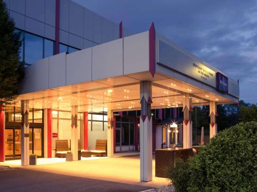 Mercure Stuttgart Sindelfingen an der Messe في شيندلفينجن: مبنى مضاء وعليه لافتة