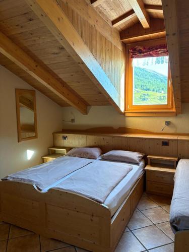 a bedroom with a bed in a wooden house at Hotel Champagne in Livigno