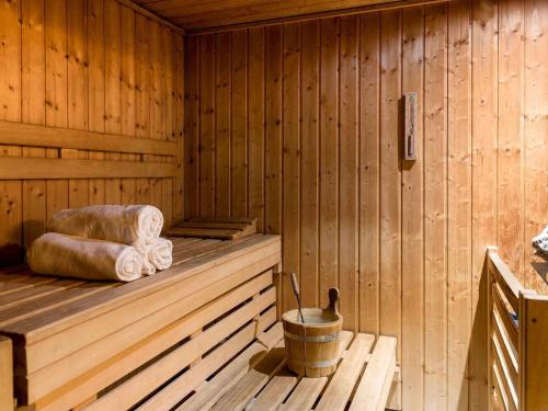 a wooden sauna with towels and a bucket in it at Novotel Genève Centre in Geneva