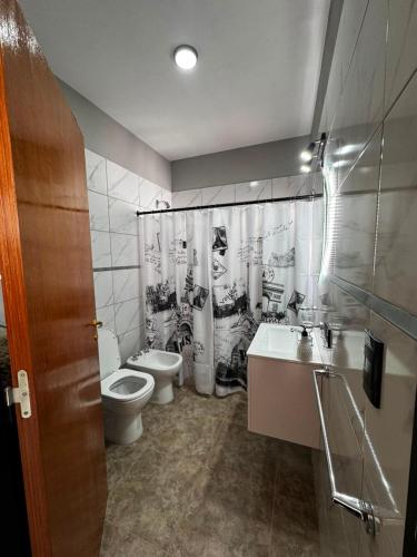 a bathroom with two toilets and a shower curtain at Alojamiento Pasaje Montes in Cruz del Eje
