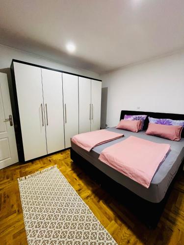 a bedroom with a bed with white cabinets and a rug at The Olive Tree Apartment in Ljubuški