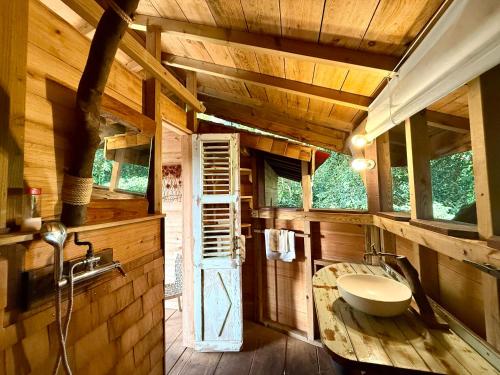 a bathroom with a toilet in a wooden house at Les Bananes Vertes Ecolodges in Saint-Claude