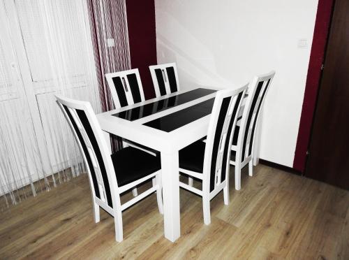 a white table with four chairs around it at Dovolenkový Dom Tatry in Vysoké Tatry
