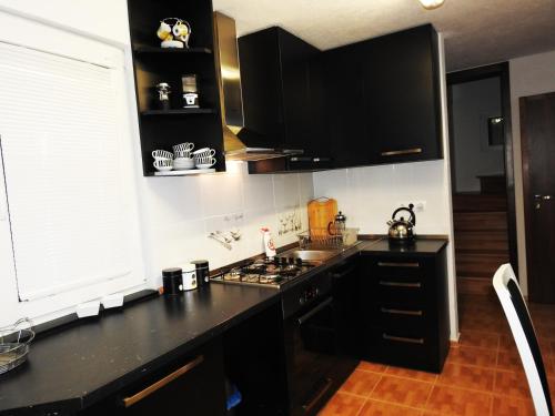 a kitchen with black cabinets and a black counter top at Dovolenkový Dom Tatry in Vysoké Tatry