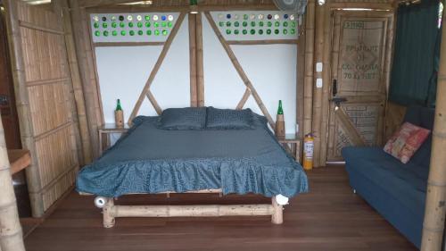 a bedroom with a bed with a blue comforter at Cabañas la pradera in Ruiosucio