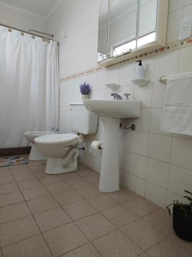 a white bathroom with a sink and a toilet at Punto Centro in Venado Tuerto