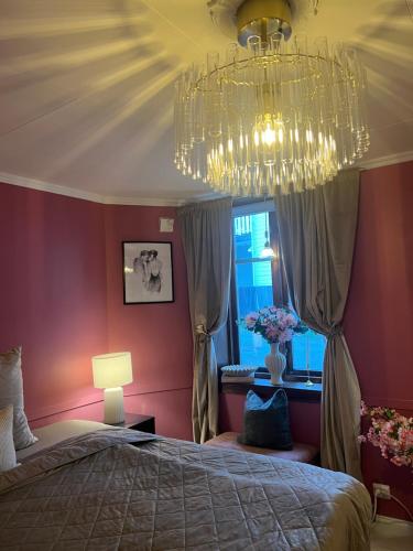 a bedroom with a large bed and a chandelier at The Old Bakery in Grimstad