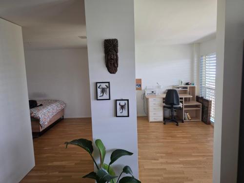 a white room with a bed and a desk at Sonnige Wohnung in Grenchen