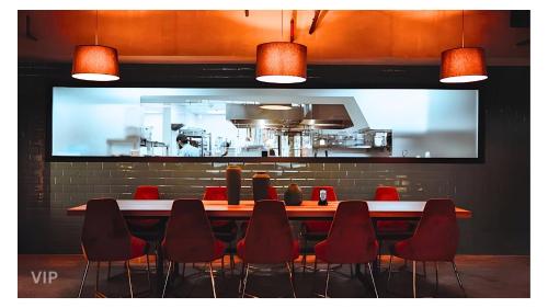 a long table with red chairs in a restaurant at VIP In Alliance Palace in Batumi