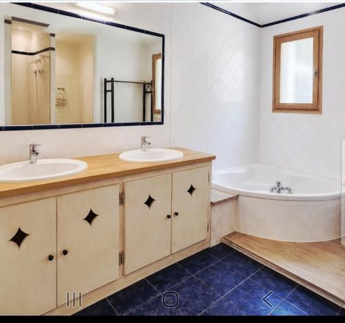 a bathroom with two sinks and a tub and a mirror at Chambre des Alpilles in Eygalières