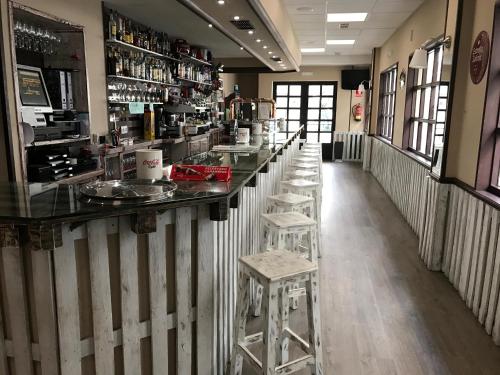 um bar com bancos no meio de um restaurante em Hostal La Frontera em Ferrol