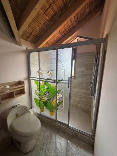a bathroom with a toilet and a glass shower at Pakarina WASY in San Miguel
