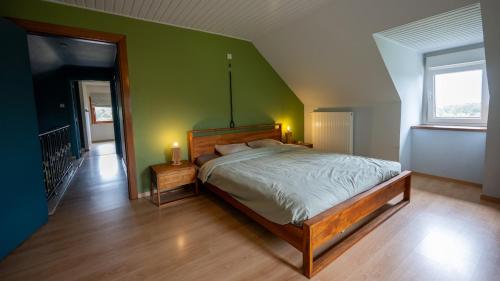 a bedroom with a bed and a green wall at Lumen nr5 in Bois