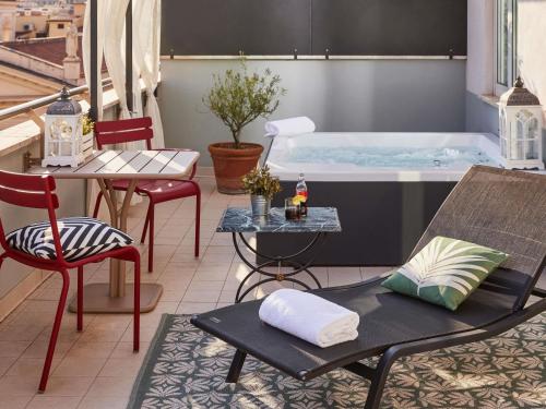 a patio with a table and chairs and a tub at Hotel Mercure Roma Corso Trieste in Rome