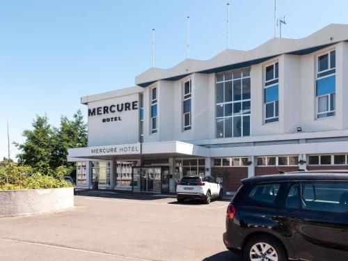 a car parked in a parking lot in front of a store at Mercure Nevers Pont De Loire in Nevers