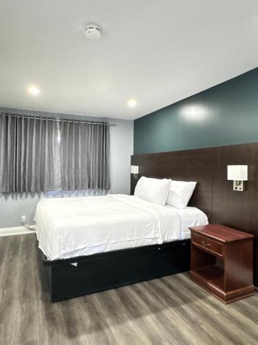 a bedroom with a large white bed and a window at Countryside Inn in Kingston