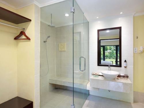 a bathroom with a sink and a glass shower at Mercure Resort Sanur in Sanur