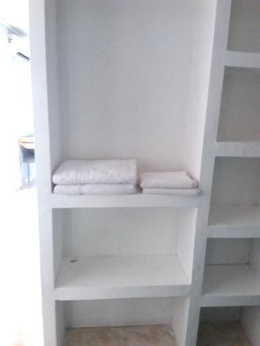 a white closet with white shelves and towels at centro 1 in General Roca