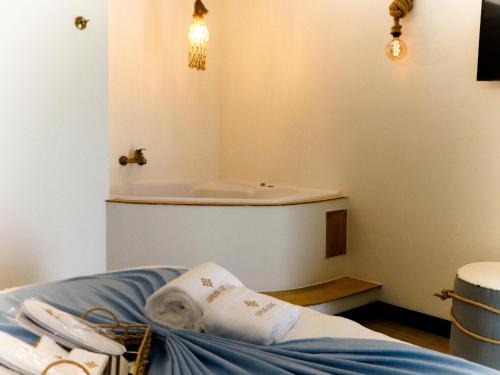 a bathroom with a tub and a bed in it at Opus One Guest House in Faro