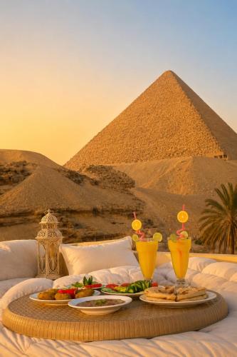 a tray of food on a bed in front of the pyramids at Crystal pyramid inn in Cairo