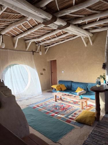 a living room with a blue couch and a table at Hobbit-Hole in Siwa in Siwa