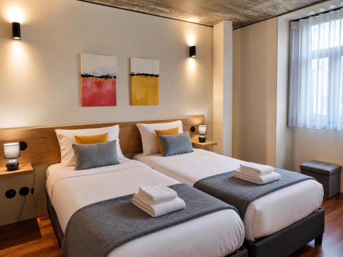 two beds in a hotel room with two bedsvisor at Fervença Apartments in Vila Nova de Gaia