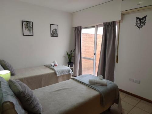 a bedroom with two twin beds and a window at Punto Centro in Venado Tuerto