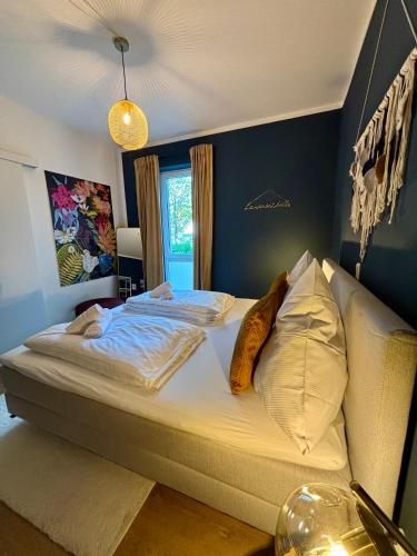 a bedroom with a large bed with white sheets and pillows at Klinik & Kurpark Parkplatz Barrierefreies Apartment Boxspringbett in Bad Oeynhausen
