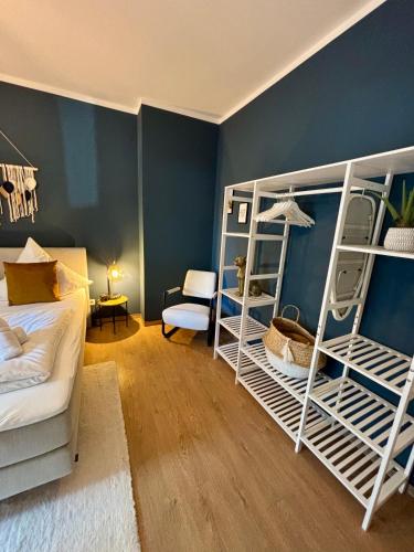 a bedroom with two bunk beds and a blue wall at Klinik & Kurpark Parkplatz Barrierefreies Apartment Boxspringbett in Bad Oeynhausen