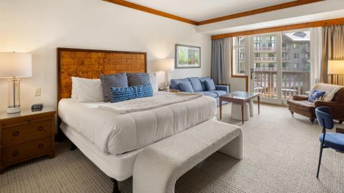a bedroom with a large bed and a living room at 347 Lodge At Spruce Peak Ski In Ski In Ski Out King Studio By Stowe Mountain Rentals in Stowe