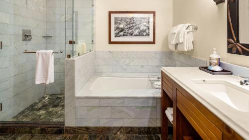 a bathroom with a tub and a sink at 347 Lodge At Spruce Peak Ski In Ski In Ski Out King Studio By Stowe Mountain Rentals in Stowe