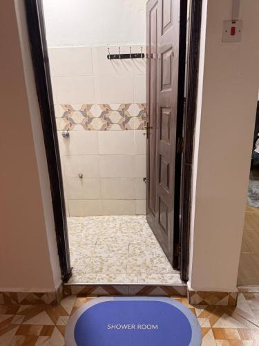 a bathroom with a shower door open to a shower room at 2020 suites utawala in Nairobi