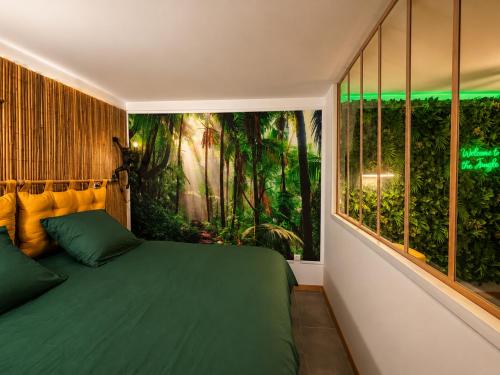 a bedroom with a green bed and large windows at La Jungle du Vernet, Ambiance Tropicale in Le Vernet