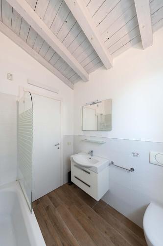 a white bathroom with a sink and a shower at Borgo Stropea by Whale Homes in Soiano del Lago
