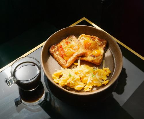 a bowl of food with toast and cheese on a table at Laureles Selection Suites in Medellín