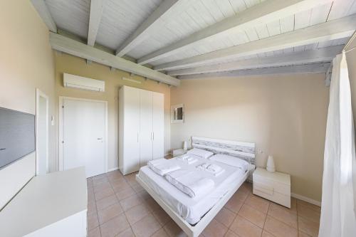 a bedroom with a large white bed in a room at Borgo Stropea by Whale Homes in Soiano del Lago